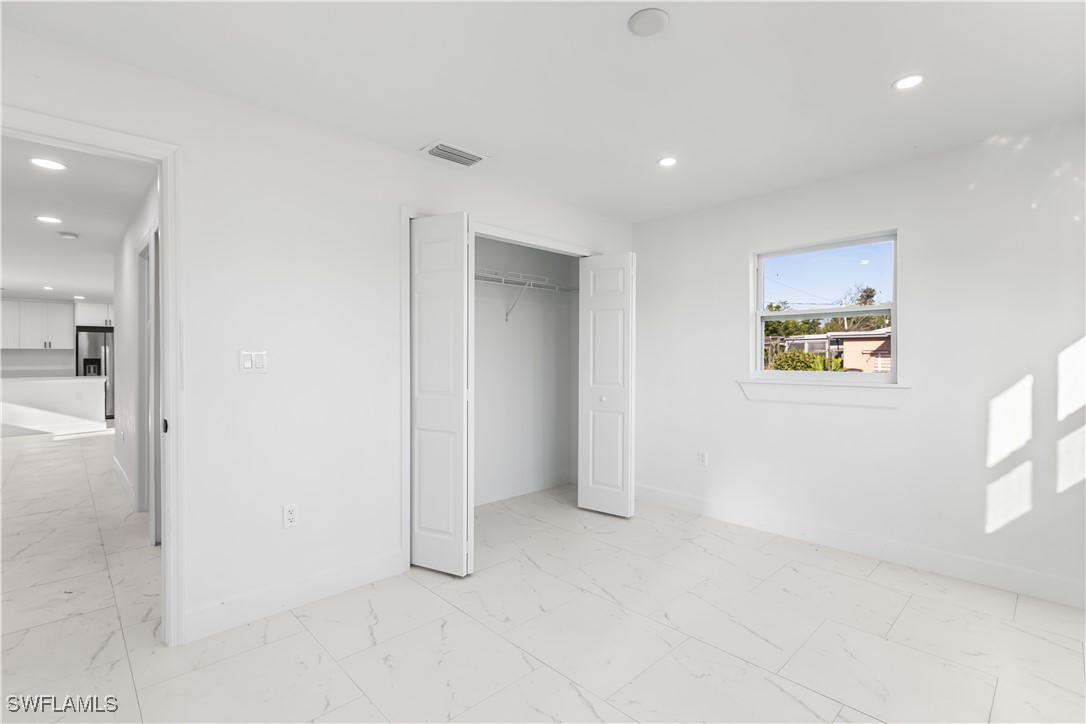 100 Wyoming Road Lehigh Acres, FL 33936 - Photo 16 of 38 en empty room with windows and entrance