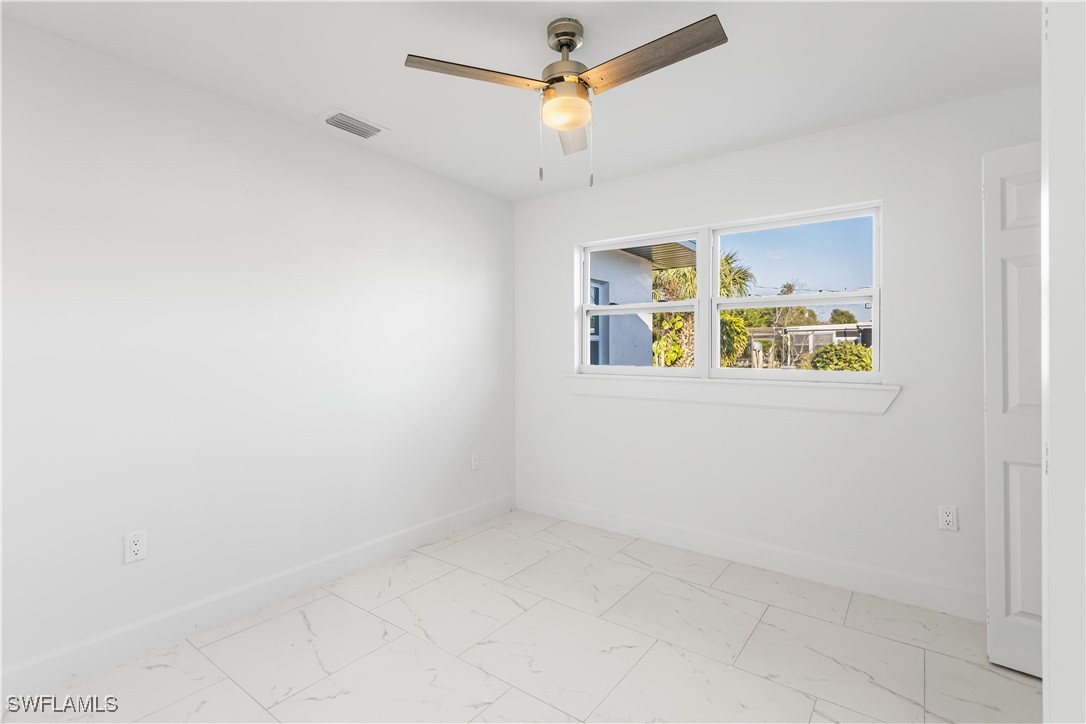 100 Wyoming Road Lehigh Acres, FL 33936 - Photo 22 of 38 an empty room with a window and ceiling fan