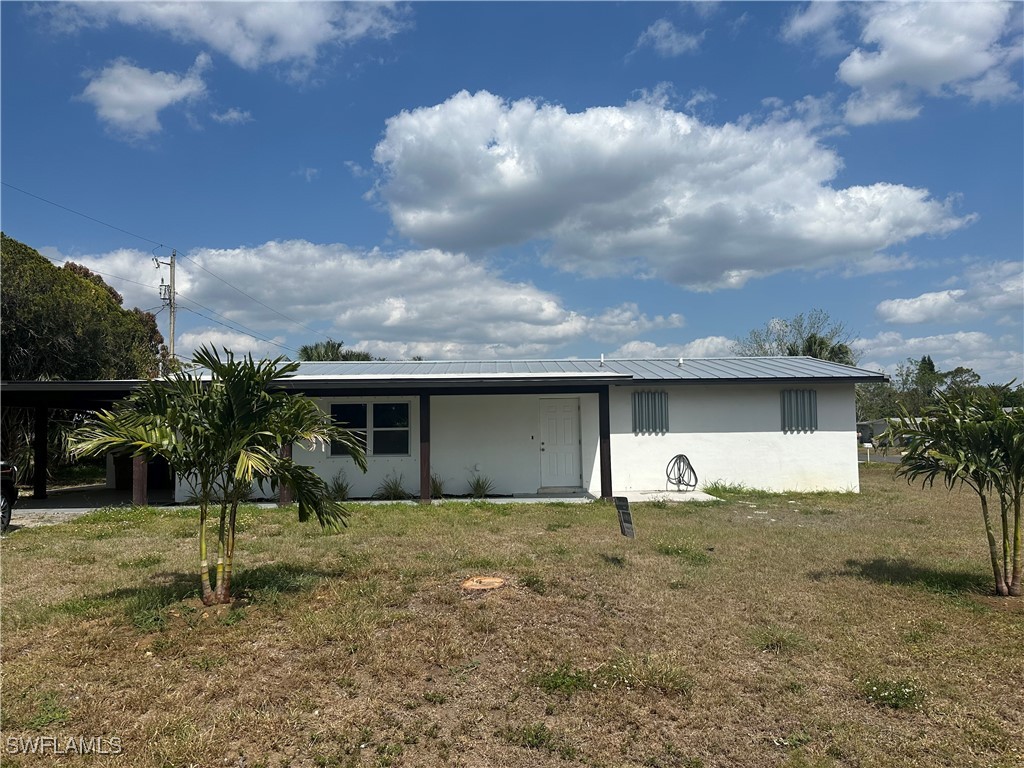 100 Wyoming Road Lehigh Acres, FL 33936 - Photo 3 of 38 a view of a house with a yard