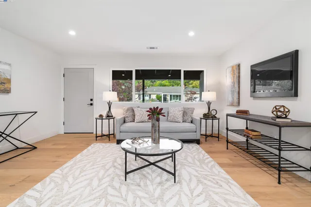 a living room with furniture a flat screen tv and a large window