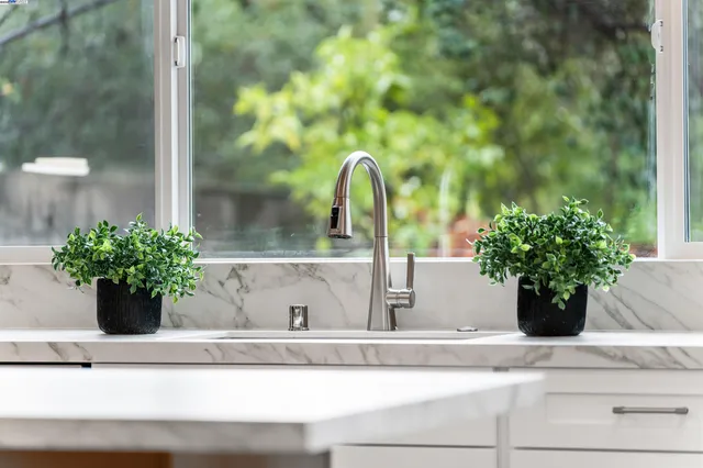 a kitchen with stainless steel appliances a refrigerator a stove a sink a dining table and chairs