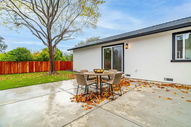 a backyard of a house with table and chairs