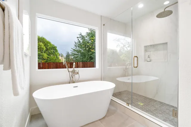 a white bath tub sitting in a bathroom next to a window