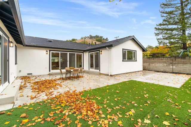 a view of a house with backyard and sitting area