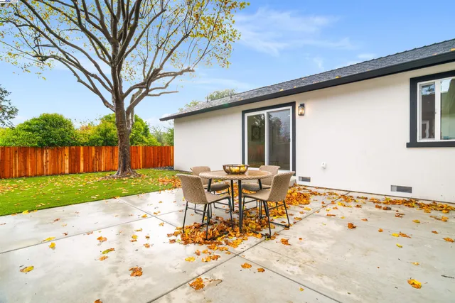 a backyard of a house with table and chairs