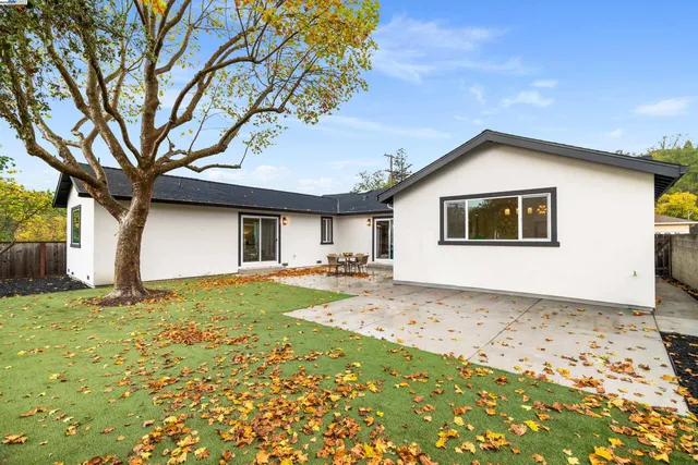 a backyard of a house with table and chairs