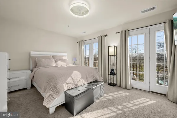 a spacious bedroom with a bed and glass door