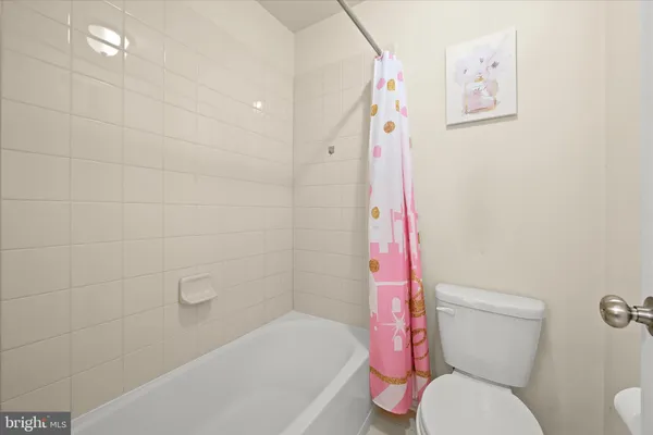 a white toilet sitting next to a bath tub