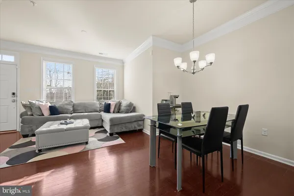 a living room with furniture a dining table and a chandelier