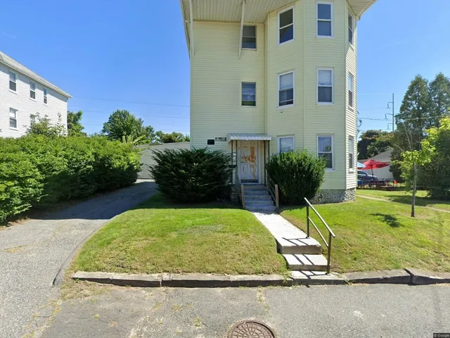 a view of a backyard with plants and outdoor seating