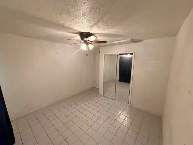 an empty room with a ceiling fan and a window