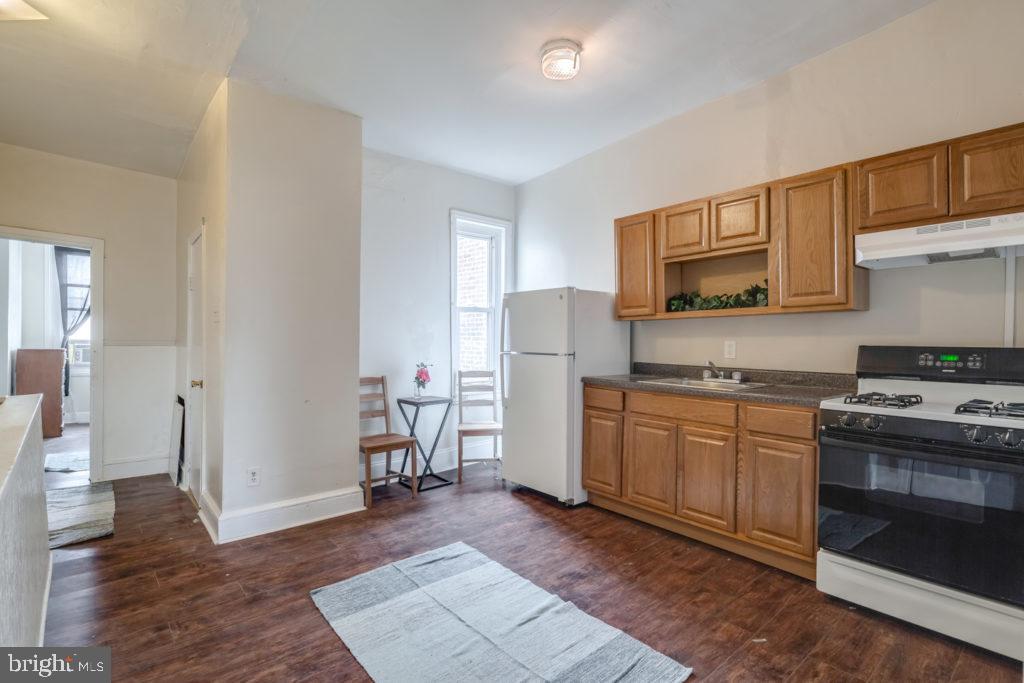 2008 South 4th Street, Unit 2 Philadelphia, PA 19148 - Photo 1 of 7 a kitchen with a refrigerator stove and wooden cabinets