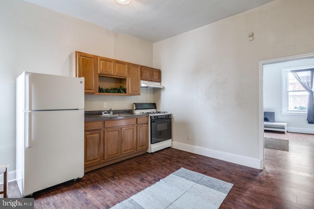 2008 South 4th Street, Unit 2 Philadelphia, PA 19148 - Photo 2 of 7 a kitchen with a refrigerator stove and wooden cabinets