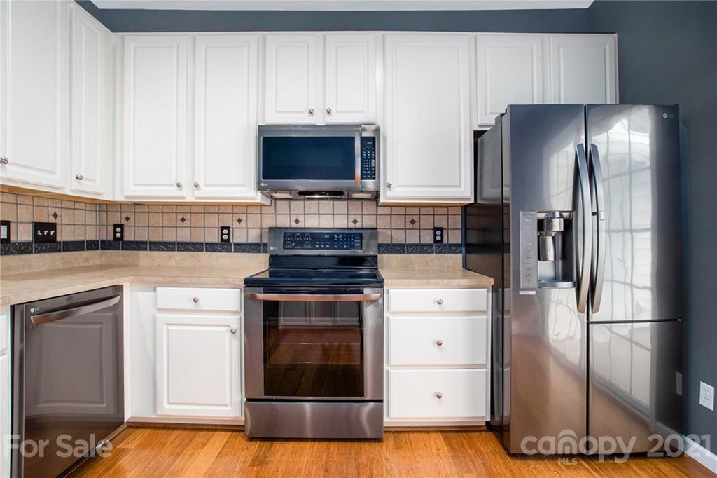 1104 Drummond Lane Matthews, NC 28104 - Photo 4 of 20 a kitchen with a stove refrigerator and microwave