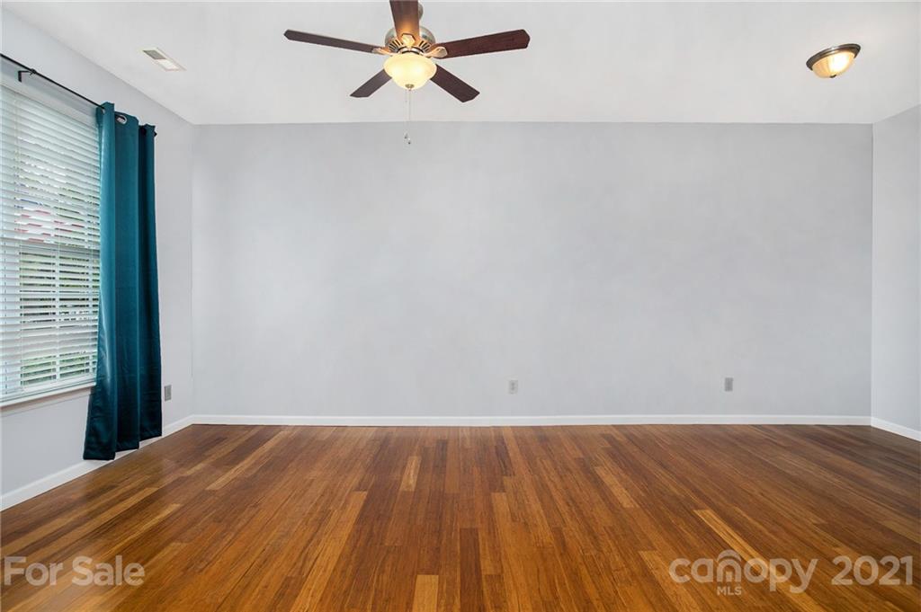 1104 Drummond Lane Matthews, NC 28104 - Photo 6 of 20 an empty room with wooden floor and windows