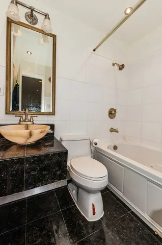 a bathroom with a sink toilet and a mirror