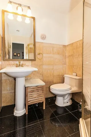 a bathroom with a toilet a sink and mirror