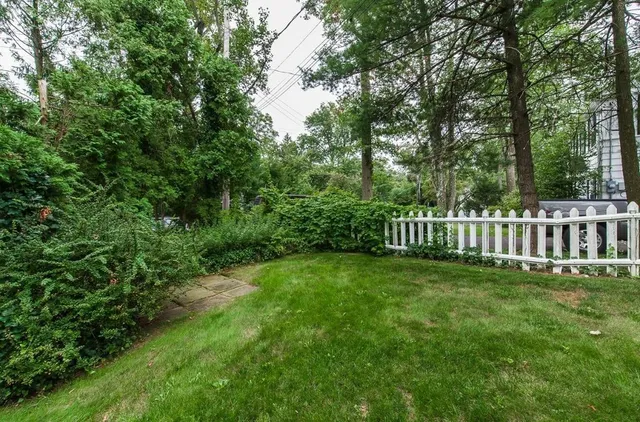 a view of a house with a yard and fence