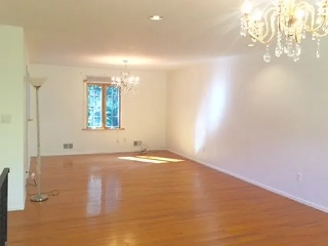 an empty room with windows and chandelier