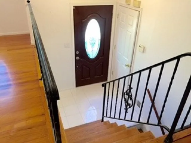 a view of staircase with white walls and a wooden floor