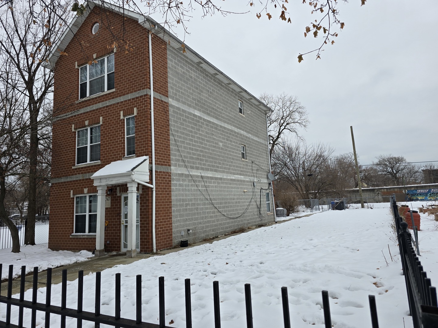 7047 South Lowe Avenue Chicago, IL 60621 - Photo 2 of 3 a view of a house with a wooden fence