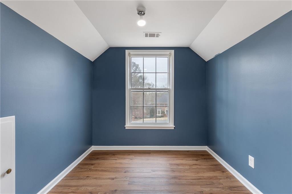 808 Valbrook Court Southwest Lilburn, GA 30047 - Photo 13 of 39 an empty room with wooden floor cabinet and windows