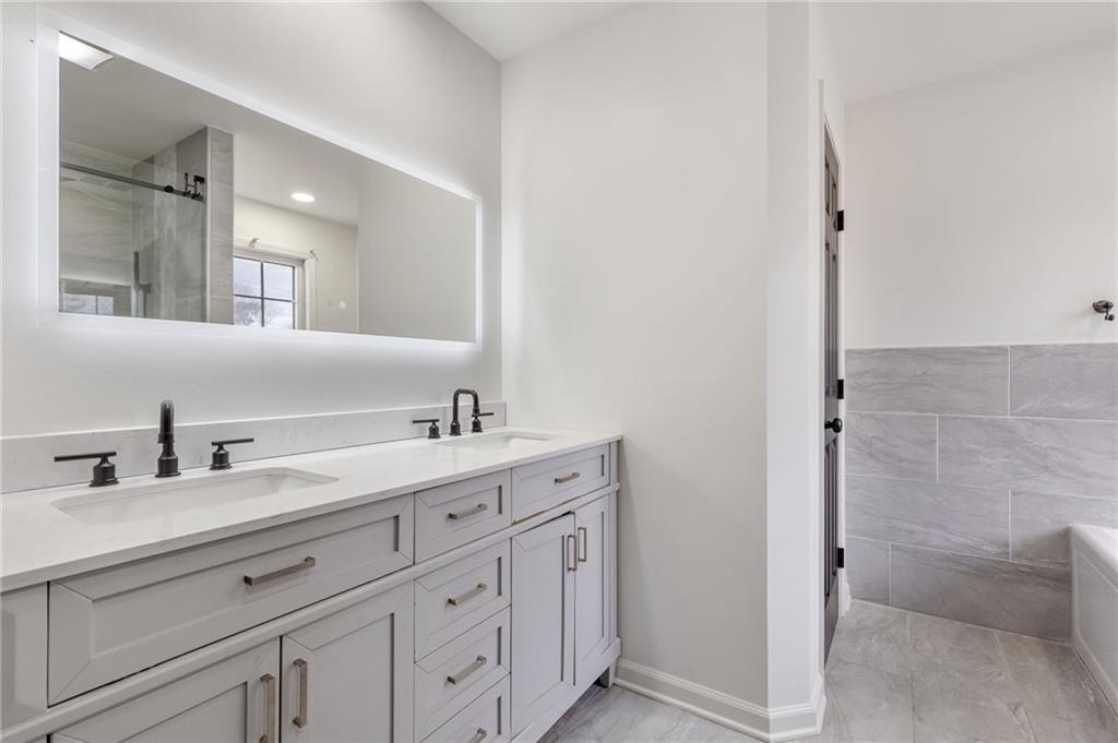 808 Valbrook Court Southwest Lilburn, GA 30047 - Photo 15 of 39 a bathroom with a double vanity sink and mirror