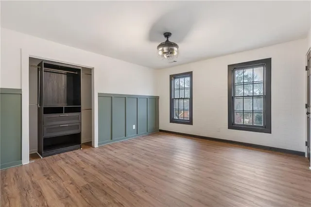 a view of a livingroom with wooden floor and a ceiling fan