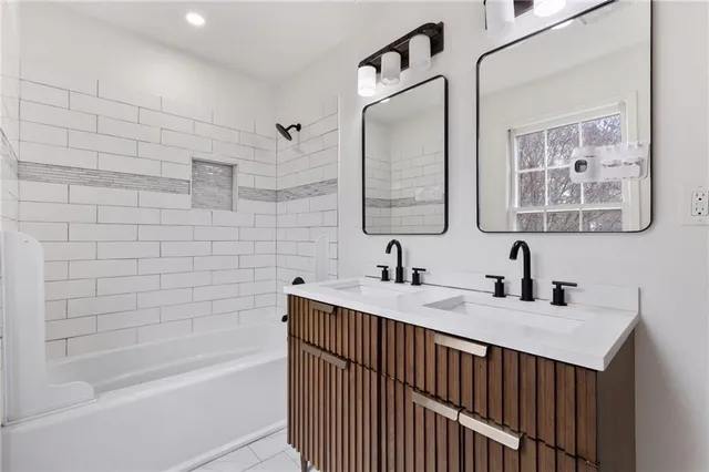 a bathroom with a sink double vanity mirror and a bathtub