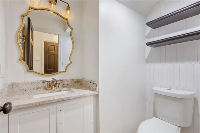 a bathroom with a toilet sink and mirror