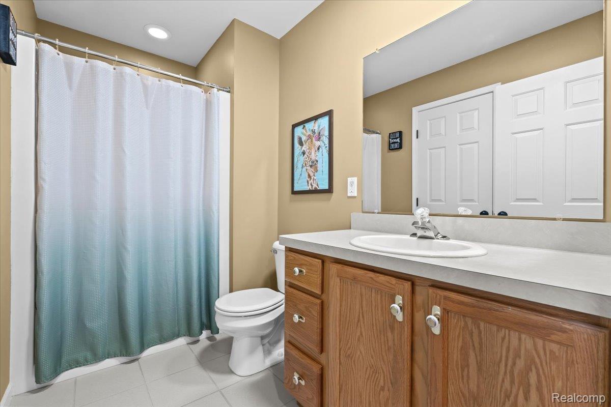3778 Warner Road Howell, MI 48855 - Photo 13 of 38 Full bath with vanity, light tile patterned flooring, and a shower with curtain