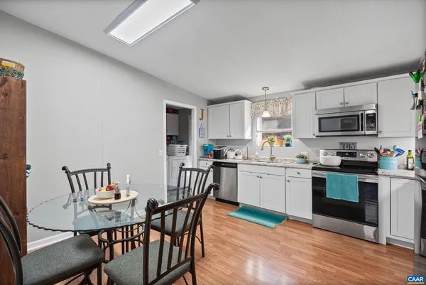 a kitchen with a table chairs microwave and cabinets
