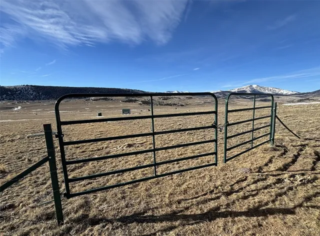a view of a dry yard with wooden fence