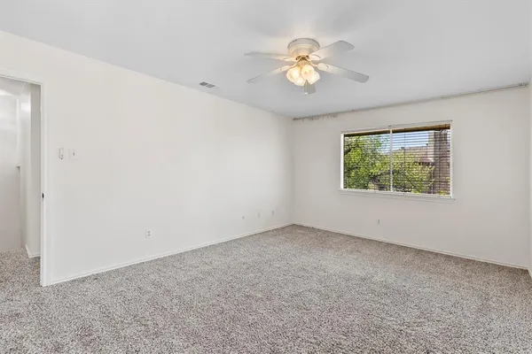 an empty room with a chandelier fan