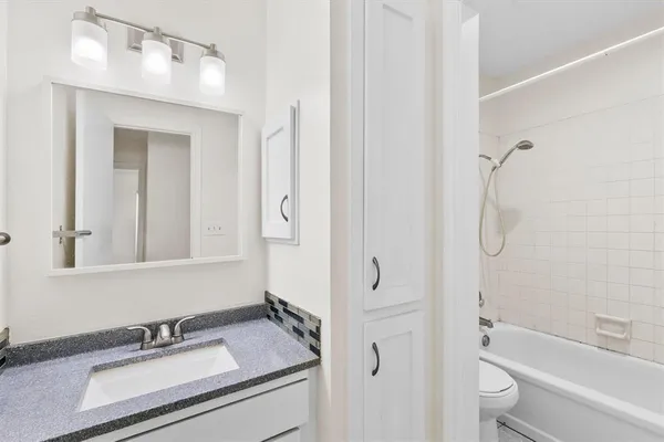 a bathroom with a granite countertop sink toilet and shower
