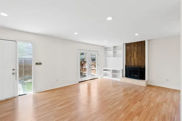 a view of an empty room with wooden floor and closet