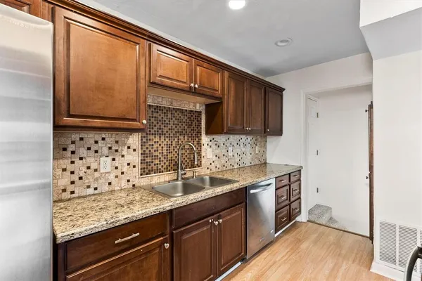 a kitchen with stainless steel appliances granite countertop a sink stove and cabinets