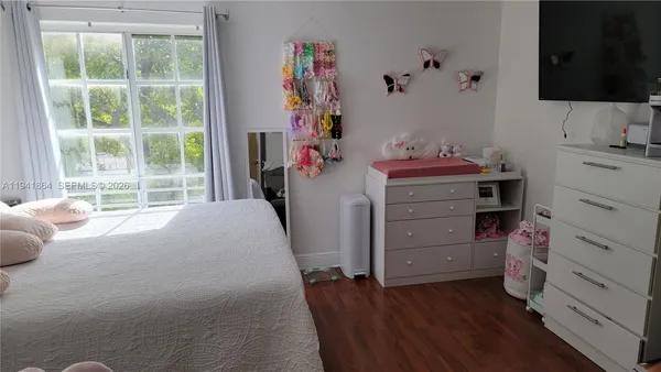 a bed room with a bed tv and a window