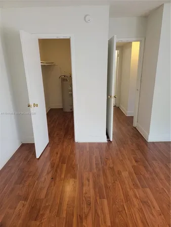 an empty room with wooden floor and entrance