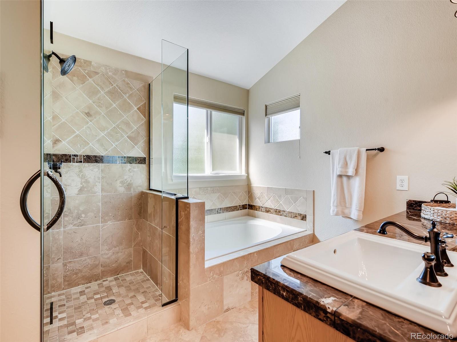 2373 Hyacinth Road Highlands Ranch, CO 80129 - Photo 13 of 38 a bathroom with a granite countertop sink a mirror and shower