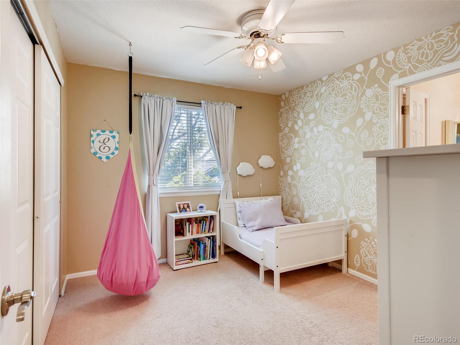 2373 Hyacinth Road Highlands Ranch, CO 80129 - Photo 15 of 38 a living room with baby crib and a chandelier