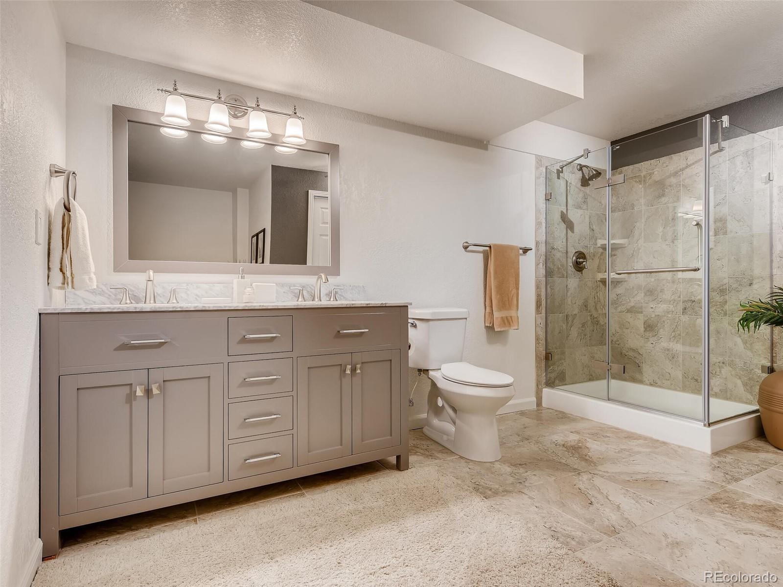 2373 Hyacinth Road Highlands Ranch, CO 80129 - Photo 21 of 38 a bathroom with a granite countertop toilet a sink and a mirror