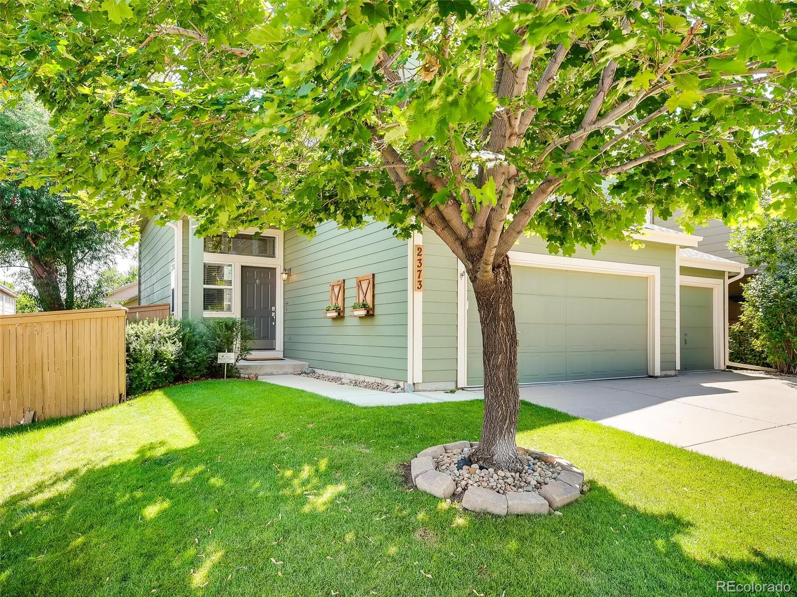 2373 Hyacinth Road Highlands Ranch, CO 80129 - Photo 30 of 38 a front view of a house with a yard and a tree
