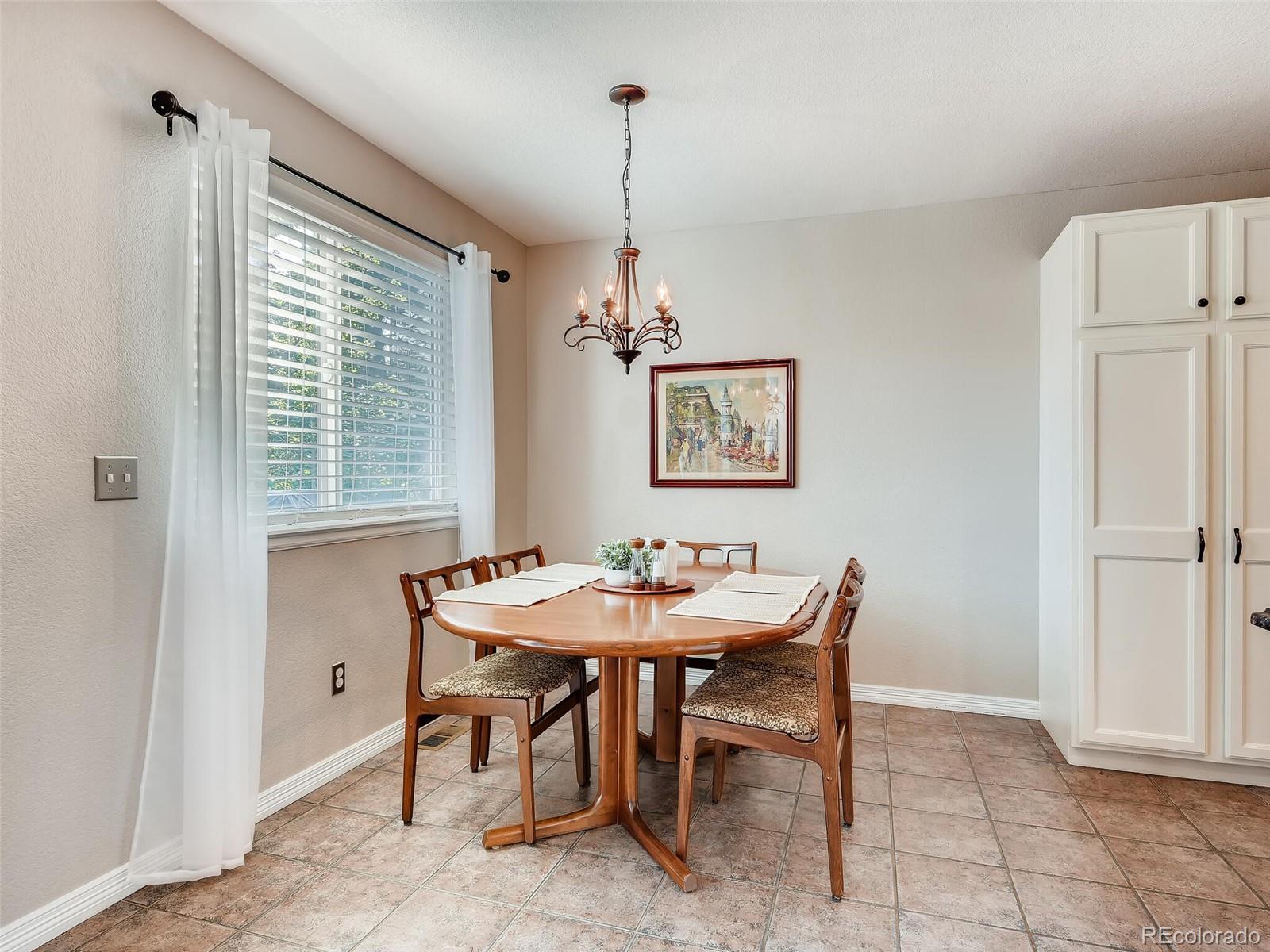 2373 Hyacinth Road Highlands Ranch, CO 80129 - Photo 7 of 38 a dining room with furniture a chandelier and window