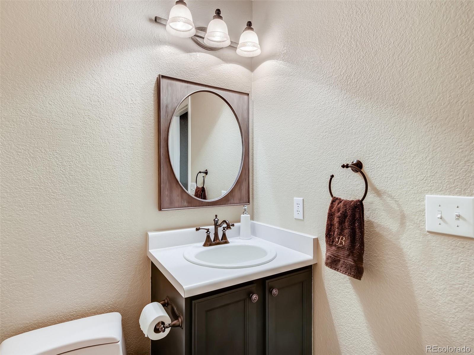 2373 Hyacinth Road Highlands Ranch, CO 80129 - Photo 9 of 38 a bathroom with a sink a light fixture and a toilet