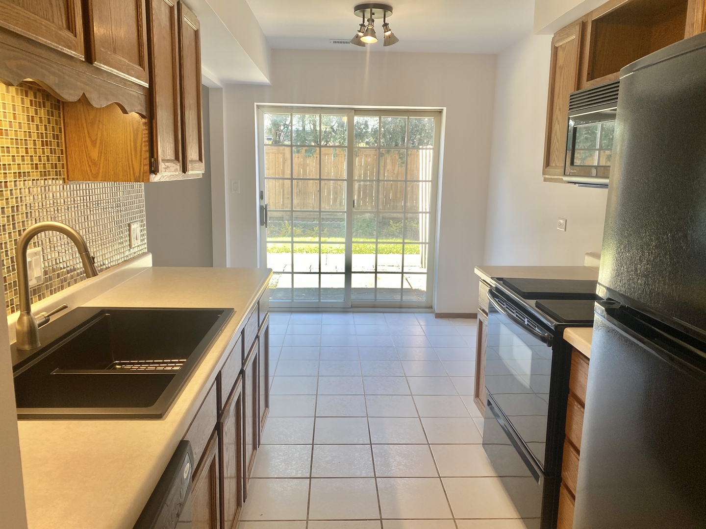 404 St Johns Road, Unit C Woodstock, IL 60098 - Photo 6 of 19 a kitchen with a stove a sink and a refrigerator