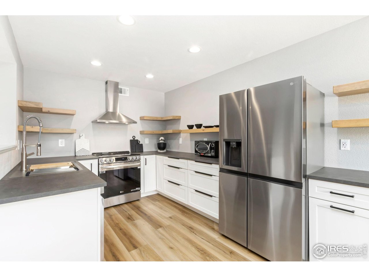 3002 West Elizabeth Street, Unit F Fort Collins, CO 80521 - Photo 2 of 18 a kitchen with granite countertop a refrigerator stove top oven and sink