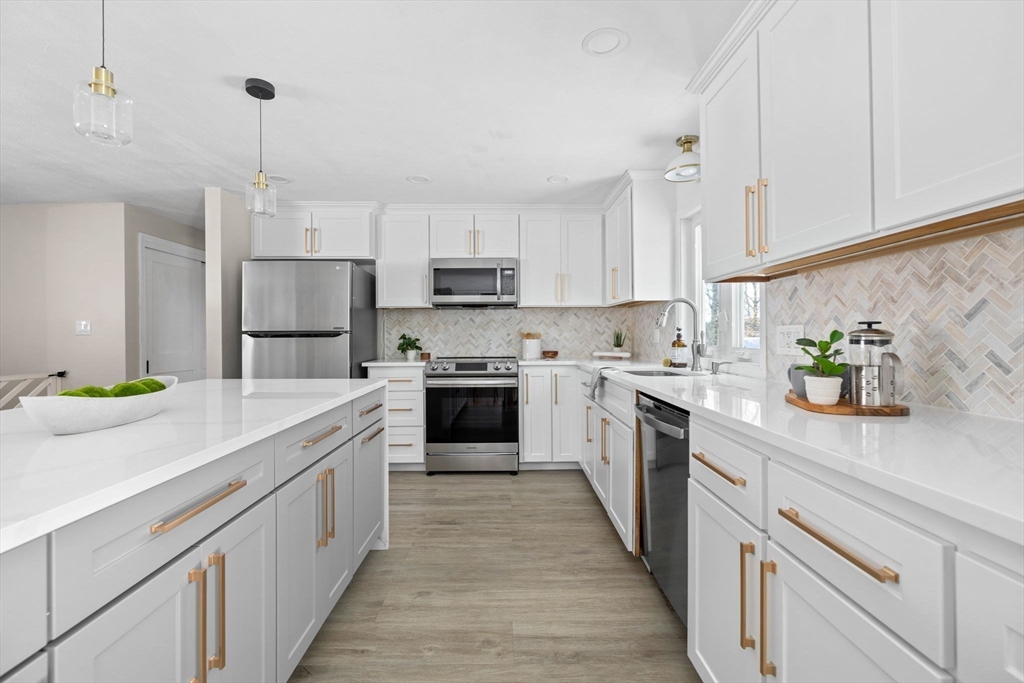 7 Dean Circle Andover, MA 01810 - Photo 11 of 36 a kitchen with kitchen island white cabinets appliances and a sink