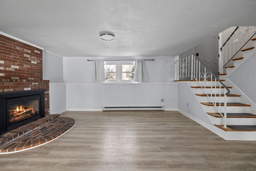 7 Dean Circle Andover, MA 01810 - Photo 30 of 36 a view of an empty room with wooden floor fireplace and a window