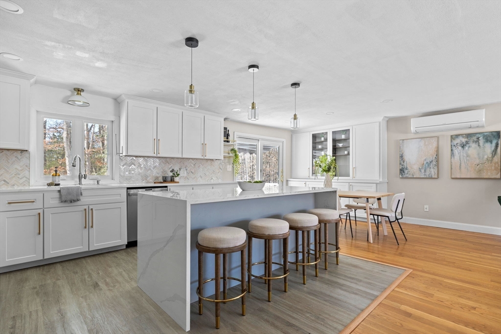 7 Dean Circle Andover, MA 01810 - Photo 8 of 36 a kitchen with granite countertop a dining table chairs and wooden floor